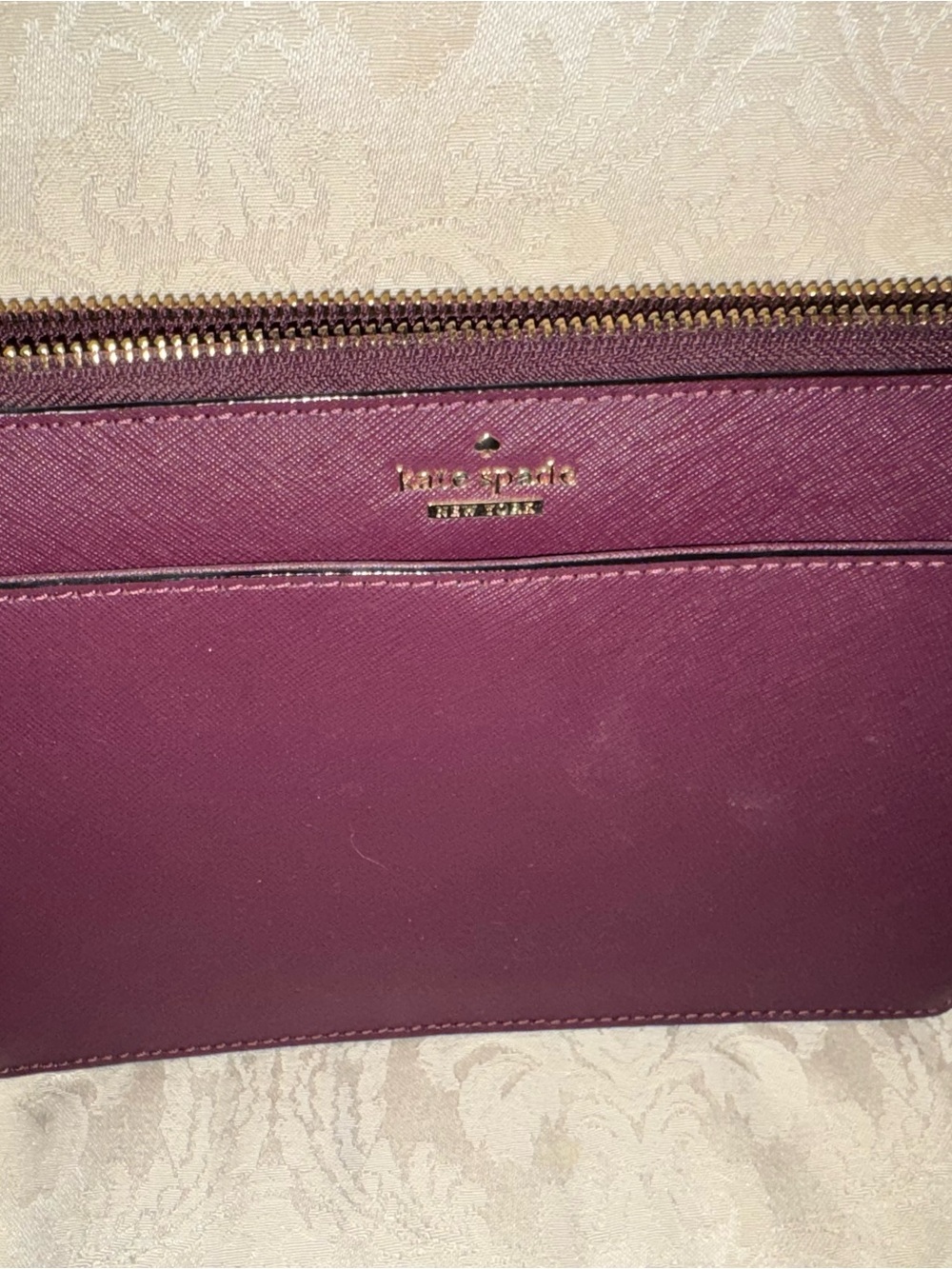 kate spade plum textured leather wristlet with gold logo